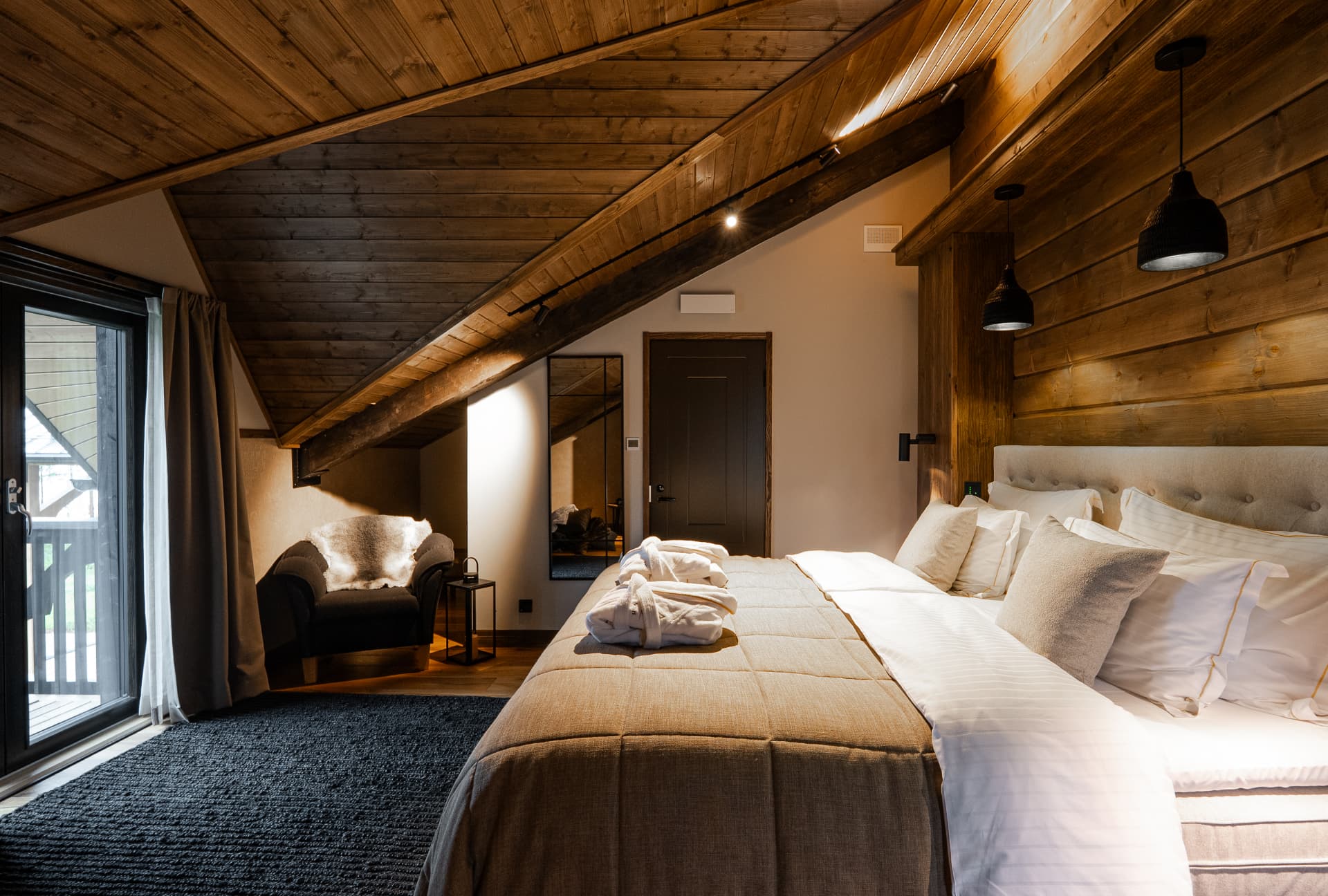 Guest suite with white linen and timber beams in the lake light at Neituri Manor, luxury accommodation in Finland